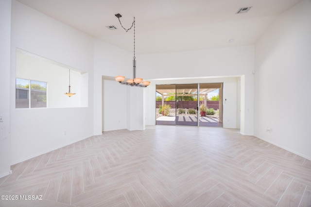 empty room featuring baseboards, a notable chandelier, and visible vents