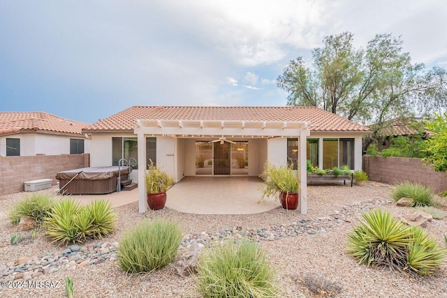 back of property featuring a hot tub, a pergola, and a patio area