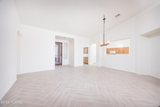 interior space featuring arched walkways, high vaulted ceiling, an inviting chandelier, and visible vents