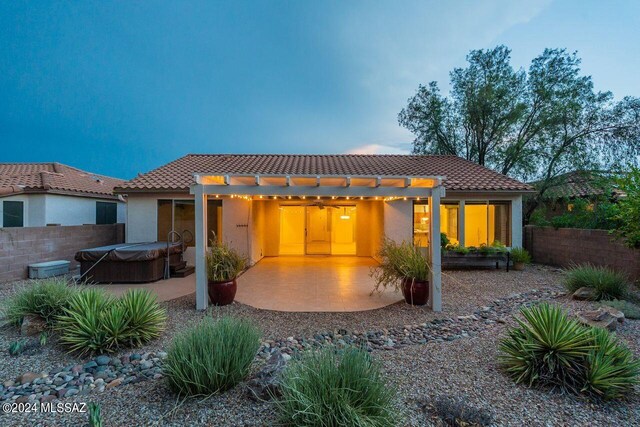 back house at dusk featuring a patio