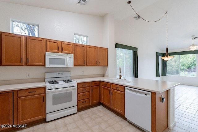 kitchen with white appliances, sink, decorative light fixtures, kitchen peninsula, and high vaulted ceiling