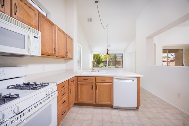 kitchen featuring a sink, white appliances, light countertops, a peninsula, and a healthy amount of sunlight