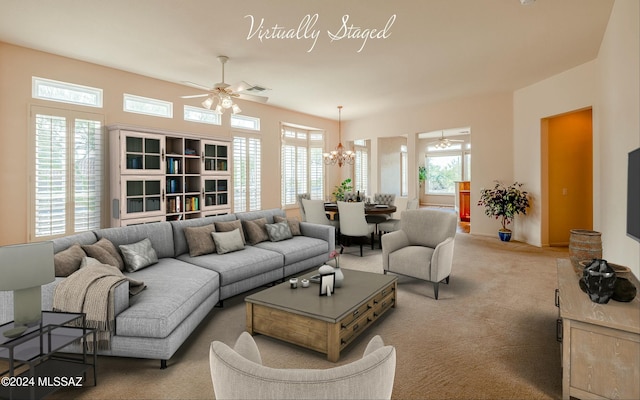 carpeted living room featuring ceiling fan with notable chandelier and a healthy amount of sunlight