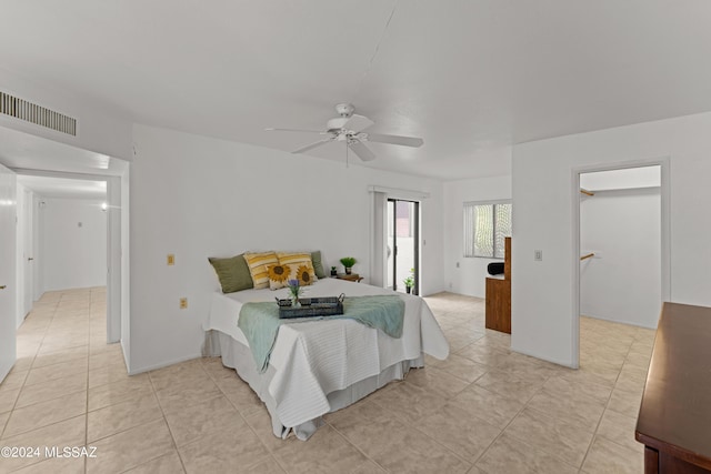 tiled bedroom with a walk in closet, access to exterior, and ceiling fan