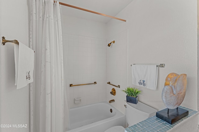 bathroom featuring shower / tub combo with curtain and toilet