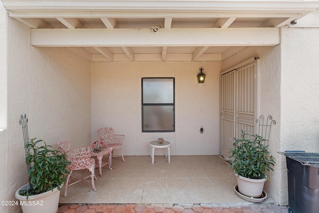 view of exterior entry with a patio area