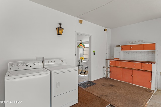 laundry area featuring washing machine and clothes dryer and light colored carpet