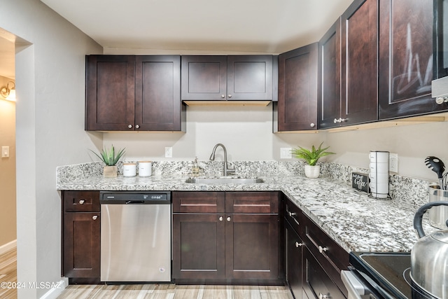 kitchen featuring light wood-type flooring, dark brown cabinets, appliances with stainless steel finishes, light stone counters, and sink