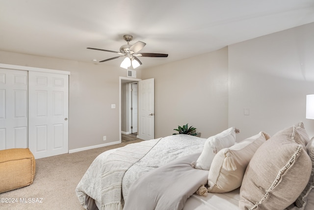 carpeted bedroom with ceiling fan and a closet