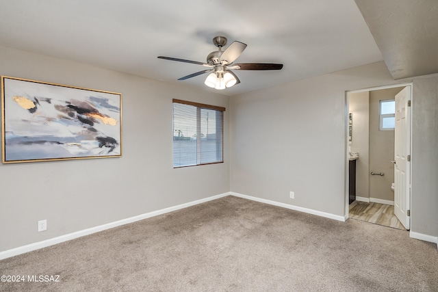 carpeted empty room featuring ceiling fan and plenty of natural light