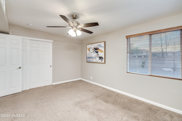 unfurnished bedroom featuring carpet flooring, a closet, and ceiling fan