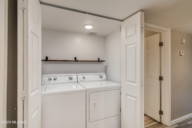 washroom with separate washer and dryer and light hardwood / wood-style floors