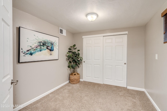 unfurnished bedroom featuring carpet flooring and a closet