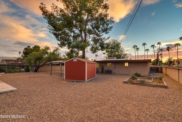 yard at dusk featuring a storage unit