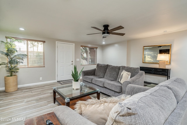 living room with light hardwood / wood-style flooring and ceiling fan