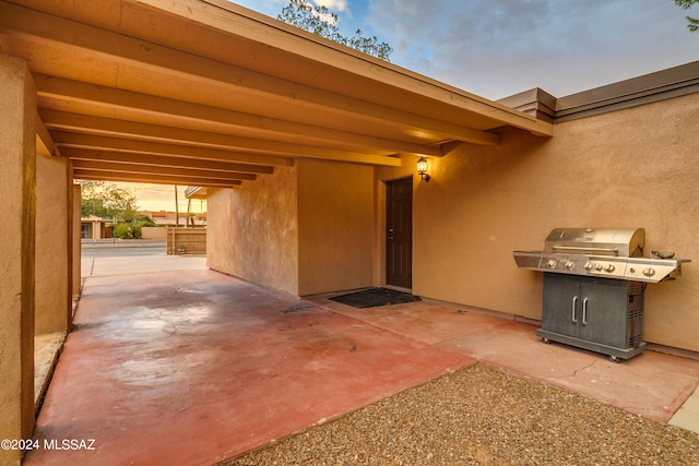 patio terrace at dusk featuring a grill