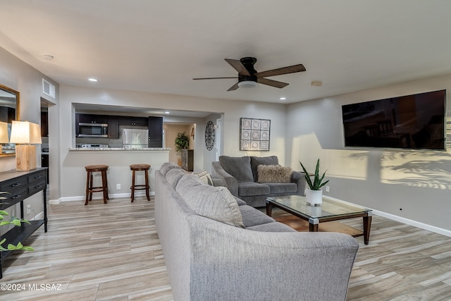 living room featuring ceiling fan and light hardwood / wood-style floors