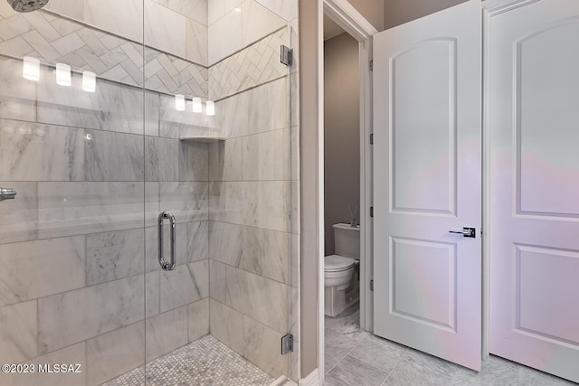 full bath with toilet, marble finish floor, and a stall shower