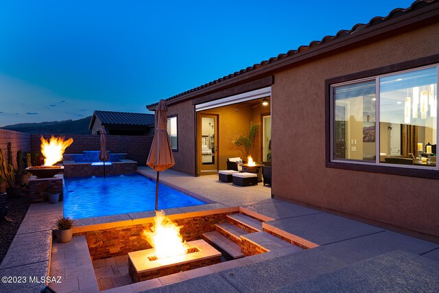 view of swimming pool with a fenced in pool, fence, a fire pit, and a patio area