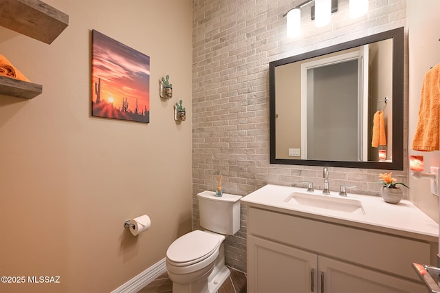 half bathroom featuring vanity, toilet, and baseboards