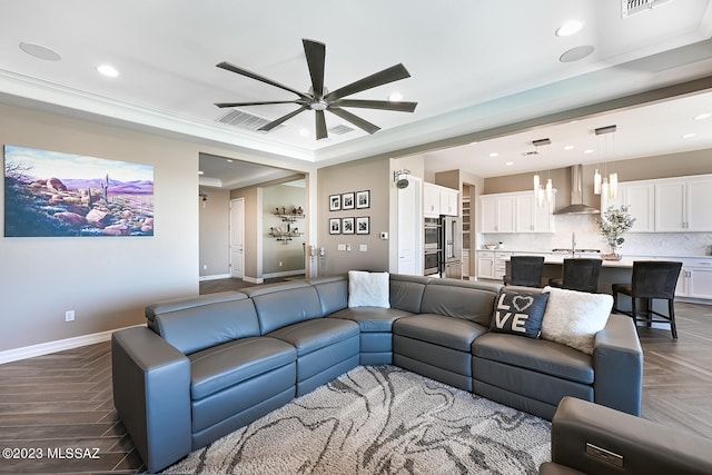 living area featuring a raised ceiling, recessed lighting, baseboards, and visible vents