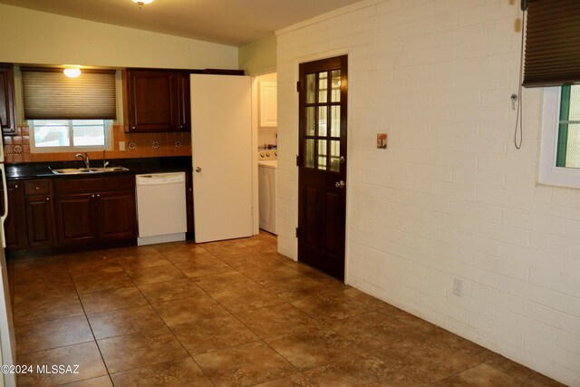 kitchen featuring light tile patterned floors, washer / clothes dryer, dishwasher, and sink