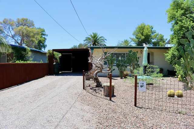 view of front of house featuring a carport and gravel driveway