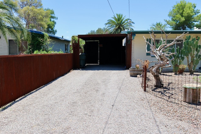 exterior space with a carport, fence, and driveway