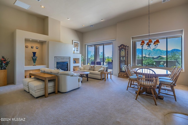 carpeted living room featuring a chandelier, a mountain view, and a high ceiling