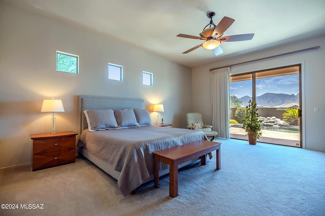 bedroom with light carpet, a mountain view, ceiling fan, and access to exterior