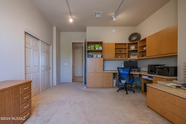 carpeted home office featuring rail lighting