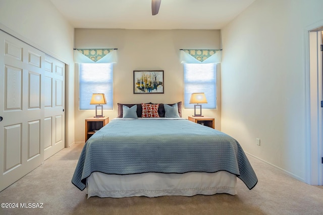 carpeted bedroom with multiple windows, ceiling fan, and a closet