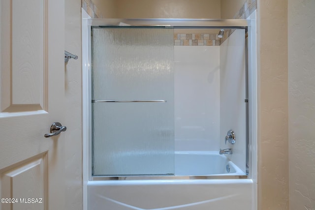 bathroom featuring bath / shower combo with glass door