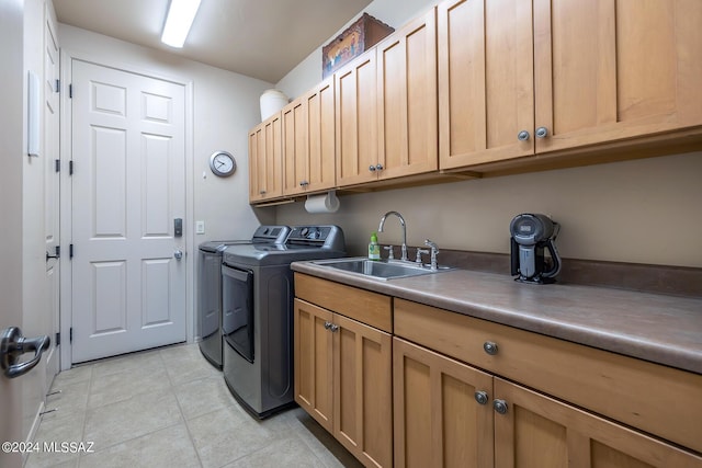 laundry room featuring sink, light tile patterned floors, washing machine and dryer, and cabinets