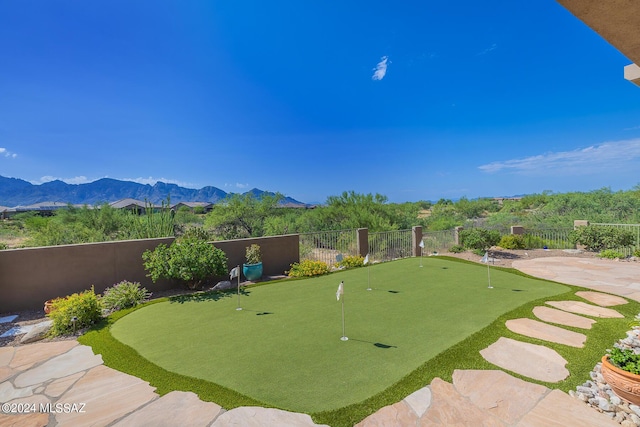 surrounding community with a mountain view and a patio