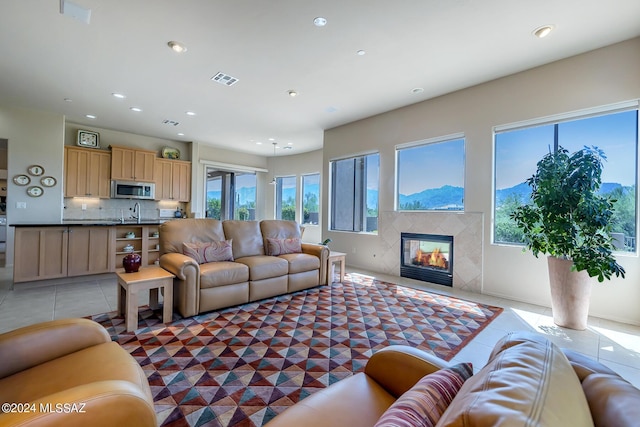 living room with a fireplace, a mountain view, and dark tile patterned floors