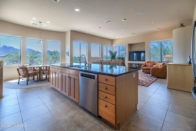 kitchen featuring sink, decorative light fixtures, a center island with sink, dishwasher, and a mountain view