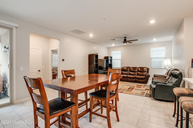 tiled dining area with ceiling fan