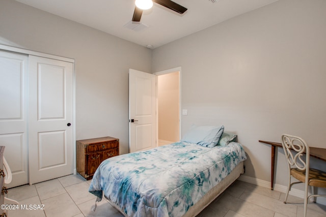 bedroom with light tile patterned flooring, ceiling fan, and a closet