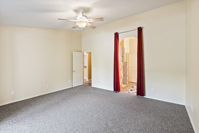 spare room featuring ceiling fan, a towering ceiling, and carpet