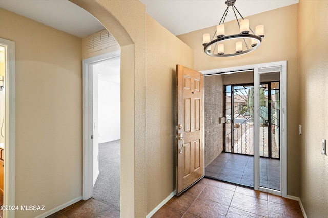 foyer with a notable chandelier and tile patterned floors