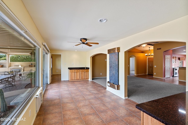 unfurnished room featuring dark colored carpet and ceiling fan