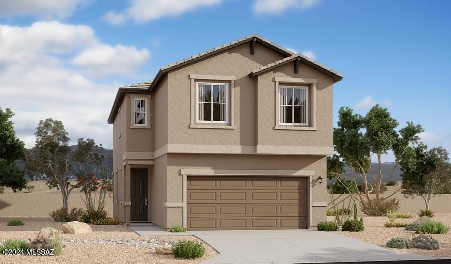 traditional-style house featuring concrete driveway, a garage, and stucco siding