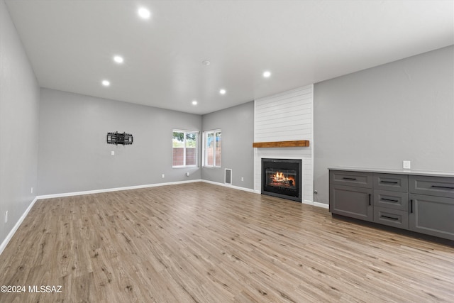 unfurnished living room featuring light hardwood / wood-style flooring and a fireplace