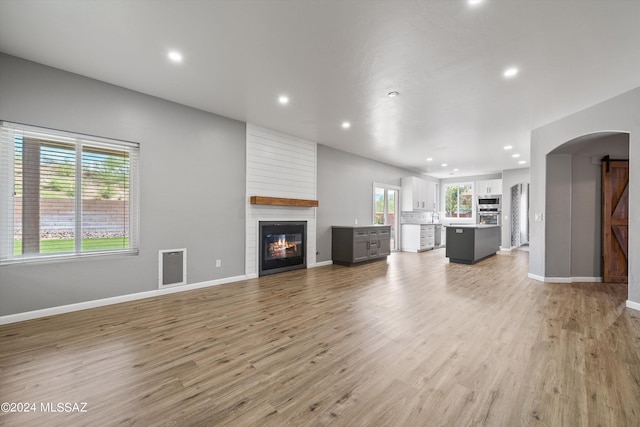 unfurnished living room with a large fireplace and light wood-type flooring