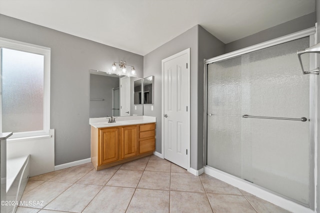 bathroom featuring vanity, a shower with door, and tile patterned flooring