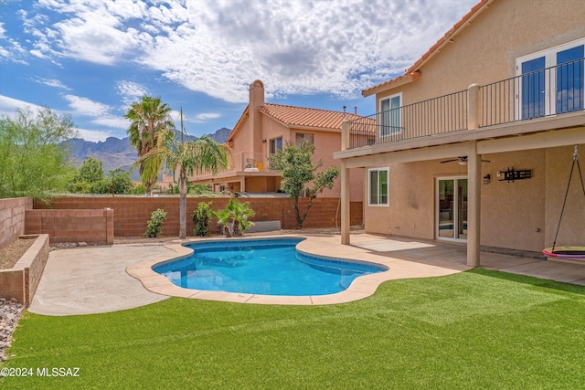 view of pool featuring a lawn, a mountain view, a patio, and ceiling fan