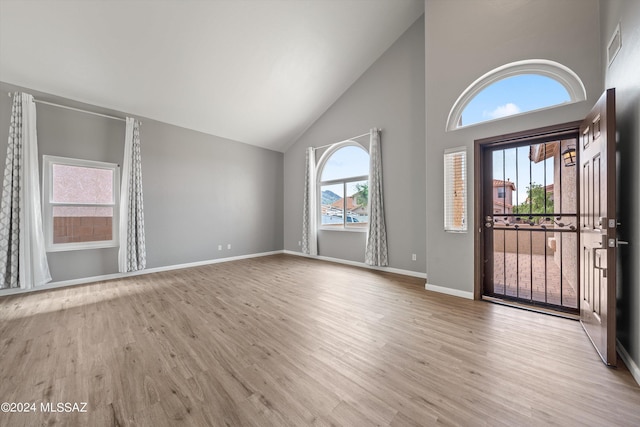 entrance foyer featuring light wood-type flooring and high vaulted ceiling