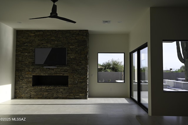 2155 E Desert Garden Dr, Tucson, AZ 85718 - living area featuring a ceiling fan, a stone fireplace, and visible vents