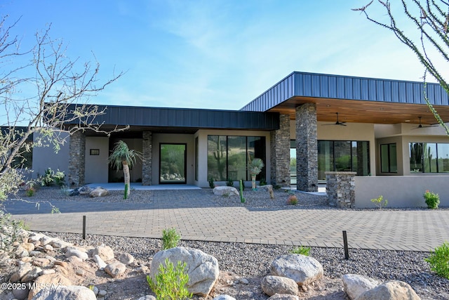 2155 E Desert Garden Dr, Tucson, AZ 85718 - back of house featuring stone siding, a ceiling fan, stucco siding, and a patio area